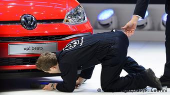 Британский комик Саймон Бродкин в костюме механика высмеивает Volkswagen на презентации в Женеве